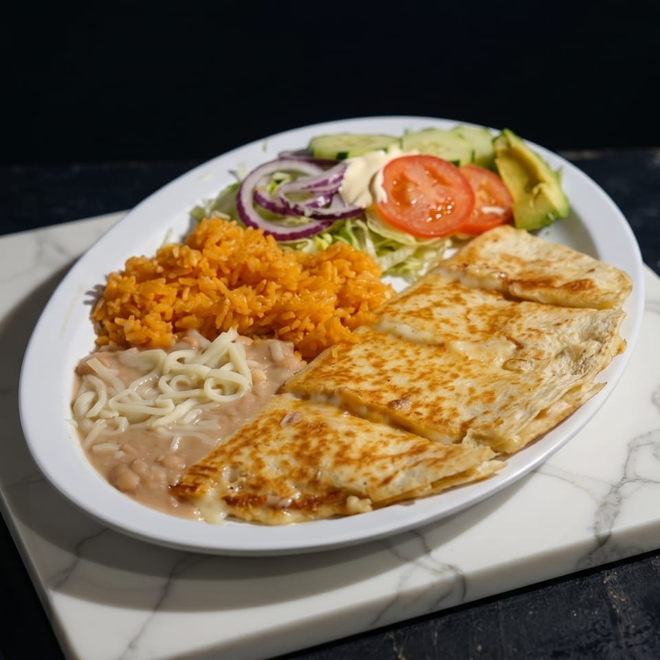 A plate of quesadillas, rice, beans, and a side salad with avocado, tomato, and onion.